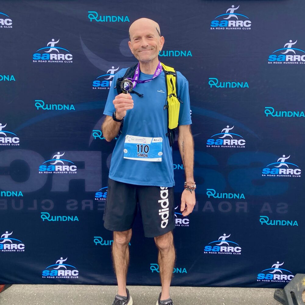 Simon holding a medal at the Barossa Marathon Festival.