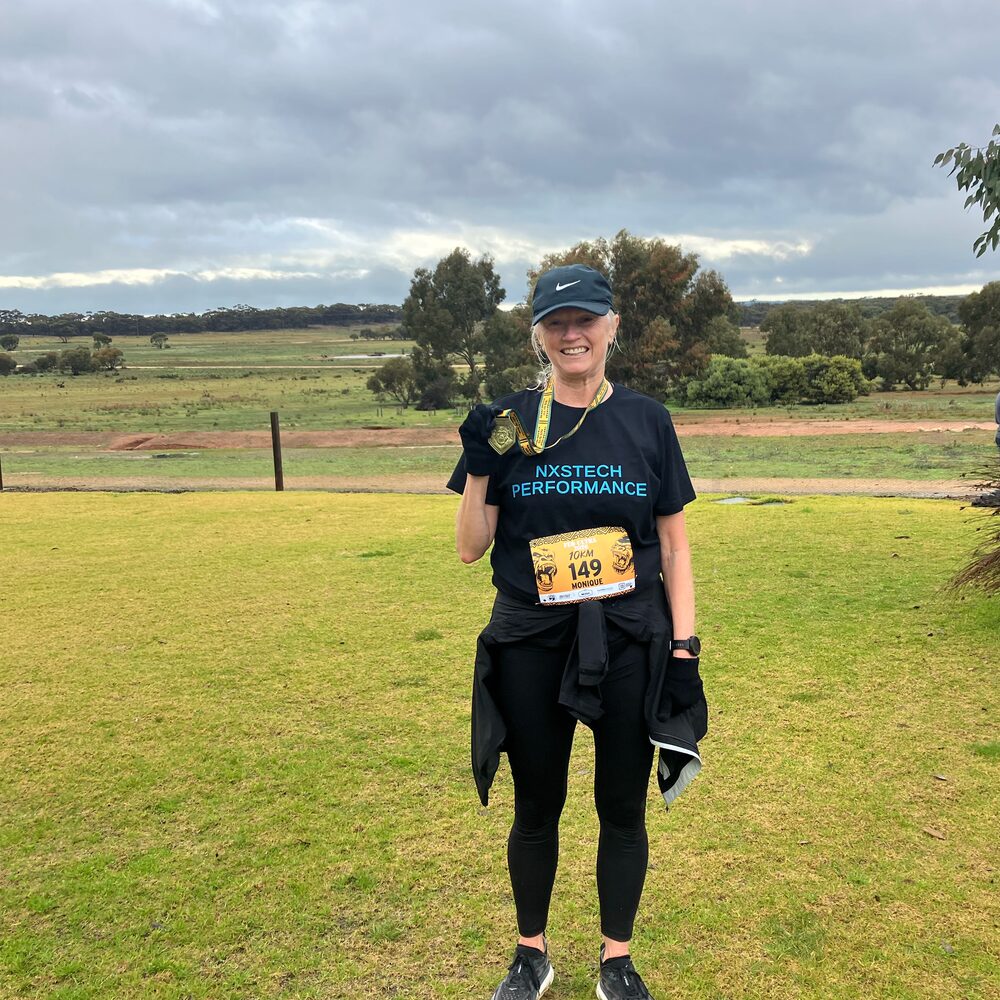 Monique finishing her 10 km wearing an NxsTech Performance shirt.